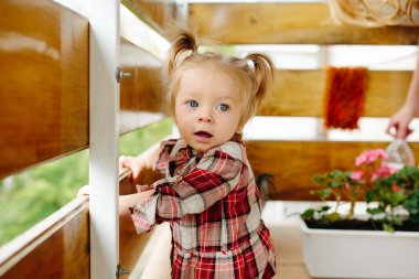 Küçük kız balkonda oynamaktan