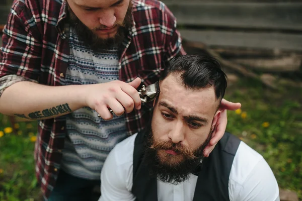 Перукар голить бородатого чоловіка — стокове фото