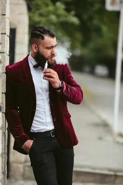 Hombre rico con barba fuma cigarrillo electrónico —  Fotos de Stock