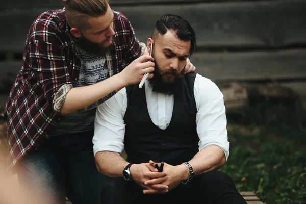 Barber shaves a bearded man — Stock Photo, Image