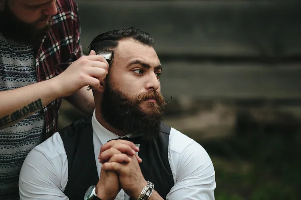 Barbiere radere un uomo barbuto — Foto Stock