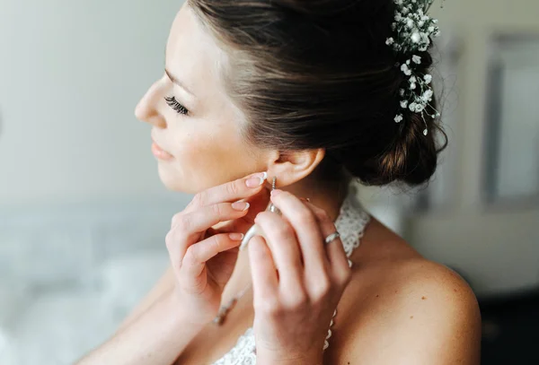 Bride puts on earrings — Stock Photo, Image