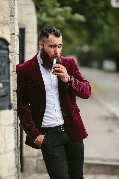 Rich man with a beard smokes electronic cigarette — Stock Photo, Image