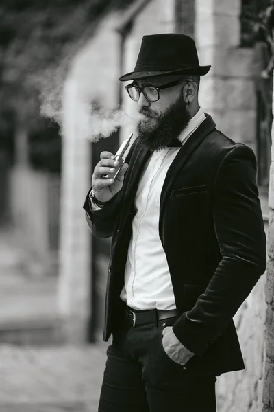 Hombre rico con barba fuma cigarrillo electrónico — Foto de Stock