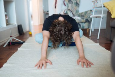Kıvırcık saçlı, öne doğru kıvırcık saçlı, halı, omurga ve omuzlar üzerinde kıvrımlı, iç mekan oturma odası dekorasyonu, yumuşak doğal ışık, sıradan.