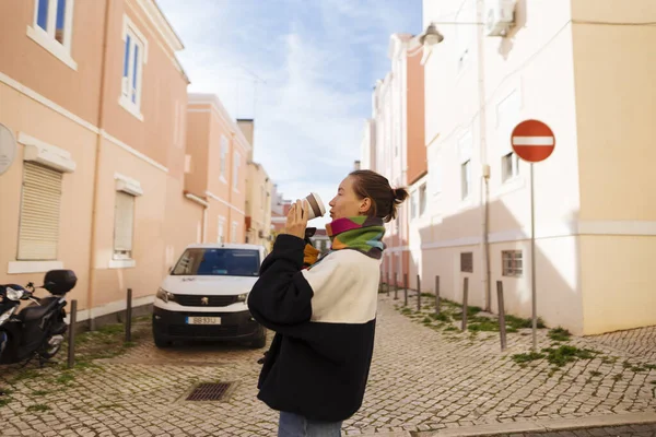 Dar pastel sokakta gezinen gezgin, güneşli cephelerde ve kaldırım taşlarının altında, sırt çantasında ve gündelik ceketinde, enerjik