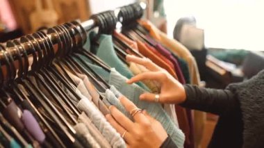 Kafkas şahsi alışverişçisi mevsimlik örgü askılarını, kaşmir ve yün kazakları, dikişleri hisseden elleri seçiyor.