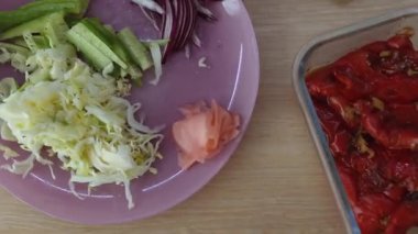 Mor salata tabağının yanında kavrulmuş biber ve patlıcanla birlikte arta kalan kaplar. Beyaz ev aşçısı kremalı sosu kavanoza boşaltıyor.,