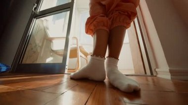 Lowangle güneşli zemin kapanışı, çoraplar ve ayak parmakları girişte dengeleniyor, nazik dans provası, turuncu koşucular, sakin atmosfer