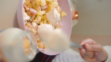 Yakın çekim kaşığı salataya kremalı sos, ev aşçısı dilimlenmiş patates ve jambona kalın topaklar, soluk pembe kase, yumuşak