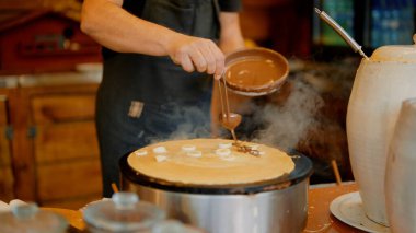 Kavanozda sıcak krep üzerine serpiştirilmiş lahanalı sos, sabit hareket eden eller, malzeme kavanozları ve buhar yaratma.
