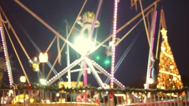 Kalabalığın üzerinde parlak ışıklar ve Noel ağacı ile uçan kayışlı gençler, yüksek enerji gösterisi, akşam festivali kalabalığı