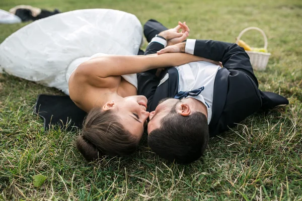 Para ślub, leżąc na trawie — Zdjęcie stockowe