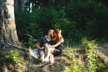 güzel çift bir orman ağacı yanında oturan