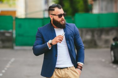 bir sakallı adam elektronik sigara içiyor