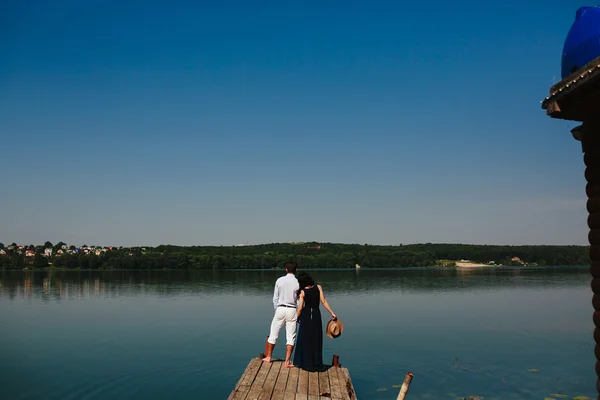 Młoda para stojąca na pokładzie nad wodą — Zdjęcie stockowe