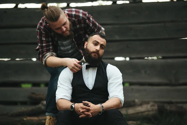 Barbero afeita a un hombre barbudo —  Fotos de Stock