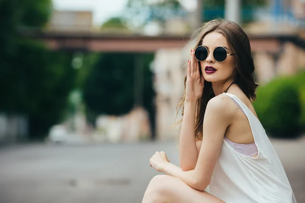 Menina bonita em óculos de sol sentado — Fotografia de Stock