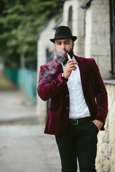 Hombre rico con barba fuma cigarrillo electrónico —  Fotos de Stock