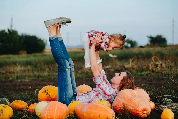 Madre e hija yacen entre calabazas —  Fotos de Stock