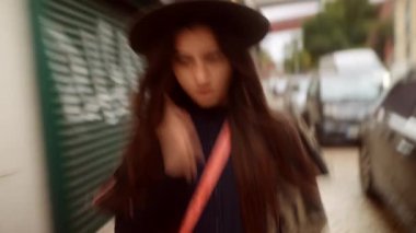 Kendine güveni tam bir kadın. Kasıtlı bir şekilde yürüyor. Şapkası ve çantasıyla.