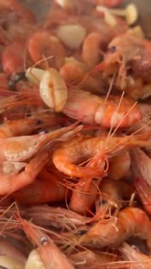 Tavada sarımsaklı cızırdayan karides, yağlı ve kabuklu pembe karideslere yakın çekim, bozulmamış kabuklar, aromalı sarımsak.,