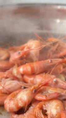 Karidesleri kaynayan tencerede sarımsaklı, kabukları pembeleşmiş ve tavada yığılmış, ritmik karıştırılmış