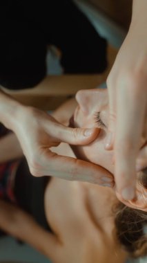 Asian woman chiropractor adjustment at clinic, hands guiding cervical vertebra with precise manual technique to improve alignment