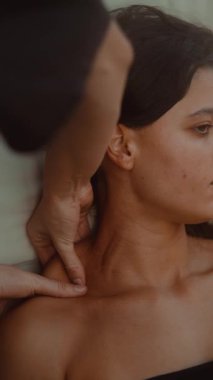 Klinik ortamlarda derin doku terapisi gören genç bir kadın. Tetikleyici noktalara hedef alınmış basınç uyguluyor.