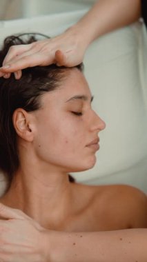 Beyaz kadın spa yüz rahatlamasından zevk alıyor, pratisyen başıyla masaj yapan çene çizgisi, yumuşak kafa derisi dokunuşu, peluş koltuk,