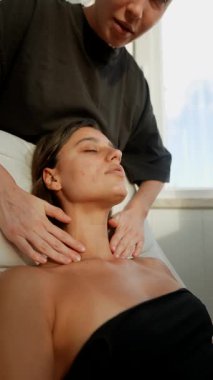 Holistik terapist göğüs seferberliği ve nefes alma, destekleyici boyun beşiği, yavaş ritmik vuruşlar, sakin stüdyo ışığı.,