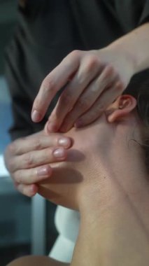 Kapalı kafkas kadın derin doku yüz seferberliği alıyor, klinisyen çene ve yanak boyunca sıkı manuel basınç uyguluyor