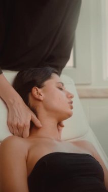 Nazik esneme ve güdümlü desteklerle boyun hareketlendirme, terapist dengeyi sağlarken başını çevirmiş bir kadın.