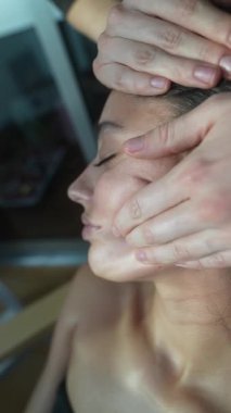 Yakın plan kadın çene masajı yaptırıyor, estetisyen, masör ve yanak boyunca sert darbeler uyguluyor, yavaş hassas basınç, klinik