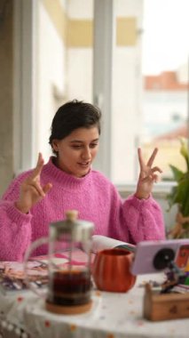 Dişi flama hareketli el hareketleri kullanır. Penceredeki kişi yayın sırasında canlı eller aracılığıyla iletişim kurar.