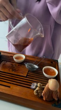 Bardaklı cam sürahi, sıcak mutfakta kehribar içen kadın, tatma rutini ve nazikçe dökme.