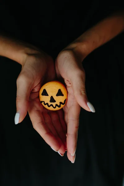 Woman holding a biscuit for Halloween — Stock Photo, Image