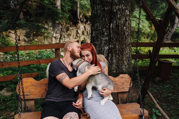Nádherný pár spolu se psem na houpačce — Stock fotografie
