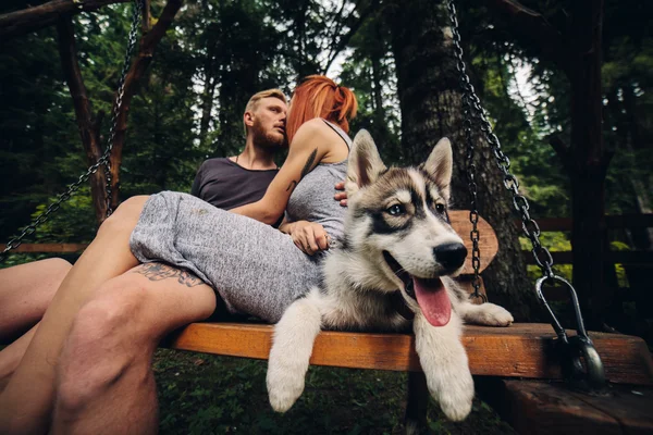 Nádherný pár spolu se psem na houpačce — Stock fotografie