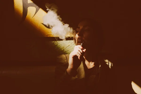 Ragazza siede e fuma sigaretta elettronica — Foto Stock