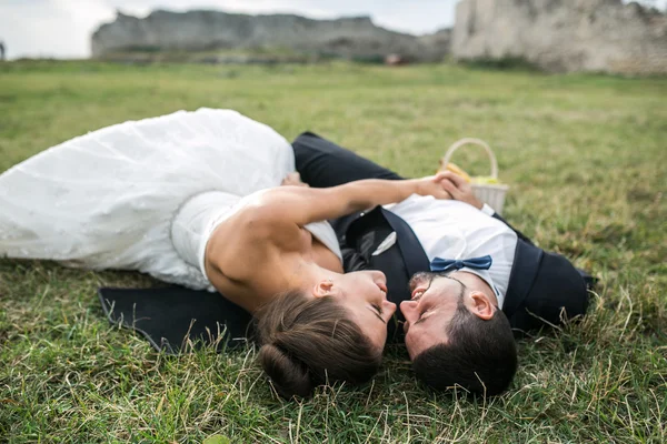 Pareja de boda acostada en la hierba —  Fotos de Stock