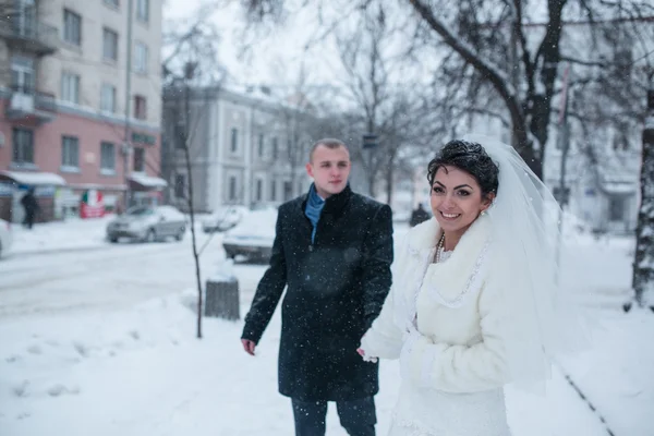 Braut und Bräutigam spazieren im Schnee — Stockfoto