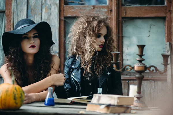 Две старинные ведьмы сидят за столом — стоковое фото