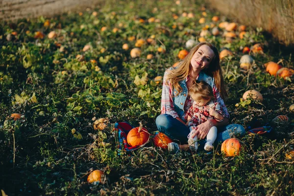 Mère et fille sur un champ avec des citrouilles — Photo