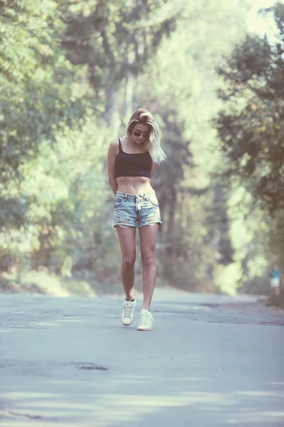 Schönes Mädchen, das eine Waldstraße hinuntergeht — Stockfoto