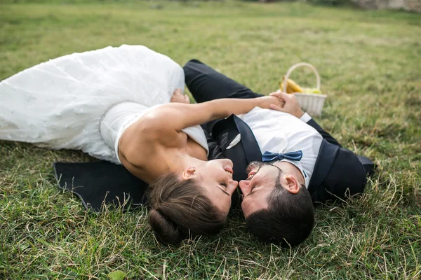 Casamento casal deitado na grama — Fotografia de Stock