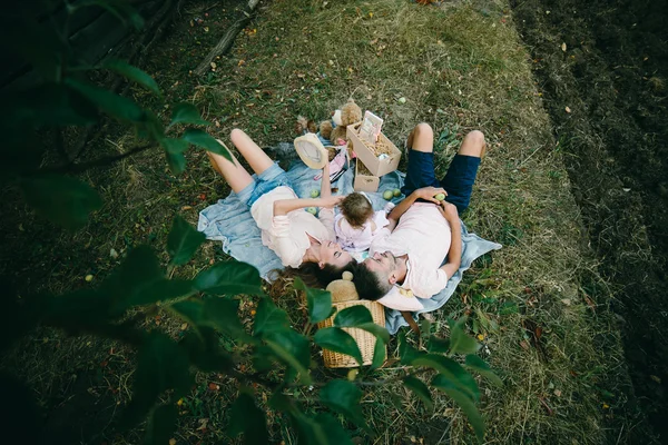 Família feliz no gramado no parque — Fotografia de Stock