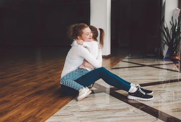 Madre e hija abrazándose en el gimnasio — Foto de Stock