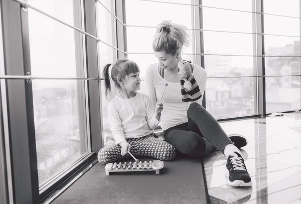 Mother and daughter playing with toys in the gym