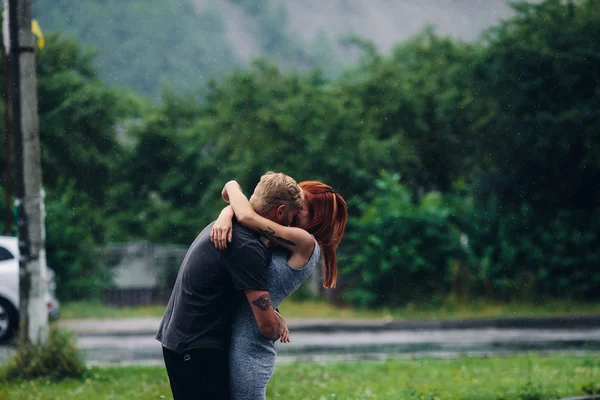 Vakkert par som klemmer i regnet – stockfoto